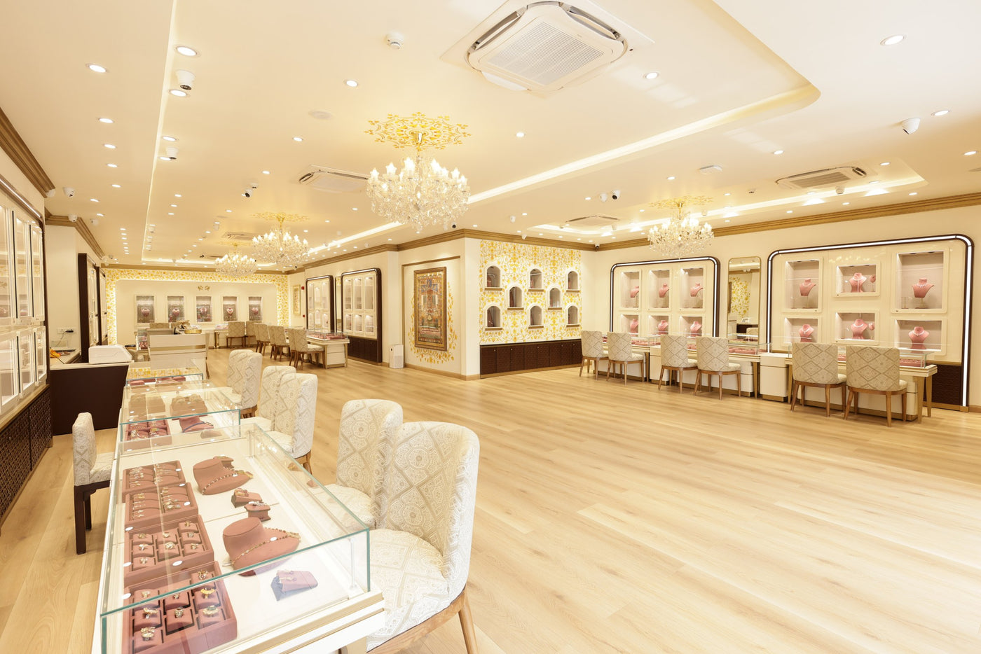 Inside a Vasundhra Raj Luxury Jewellery store: crystal chandeliers, velvet trays and chairs along the counters