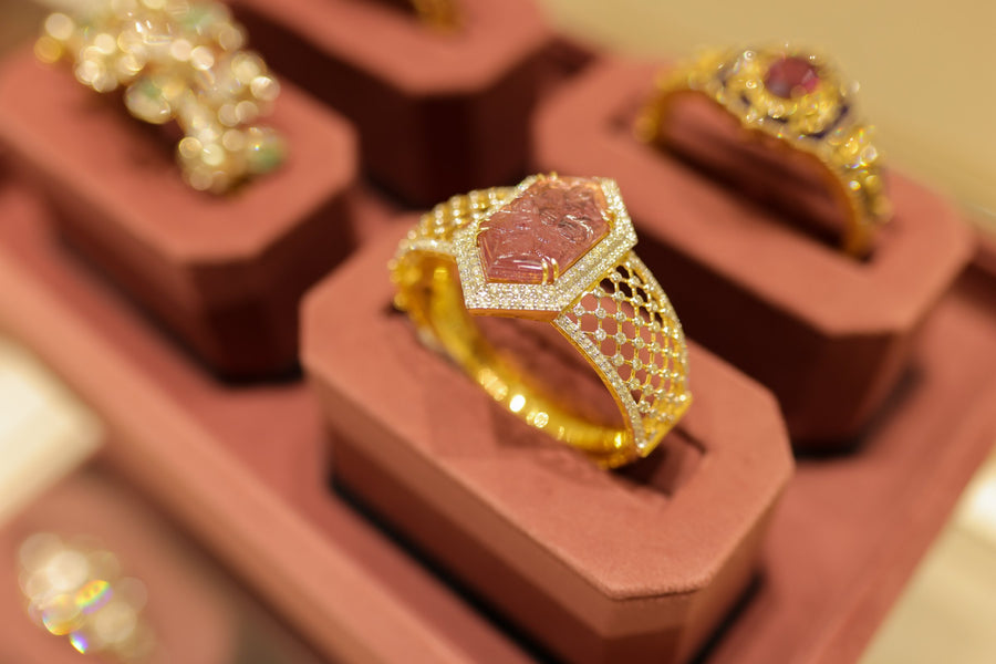 Rings of polki and rubies on maroon velvet stands at the counter