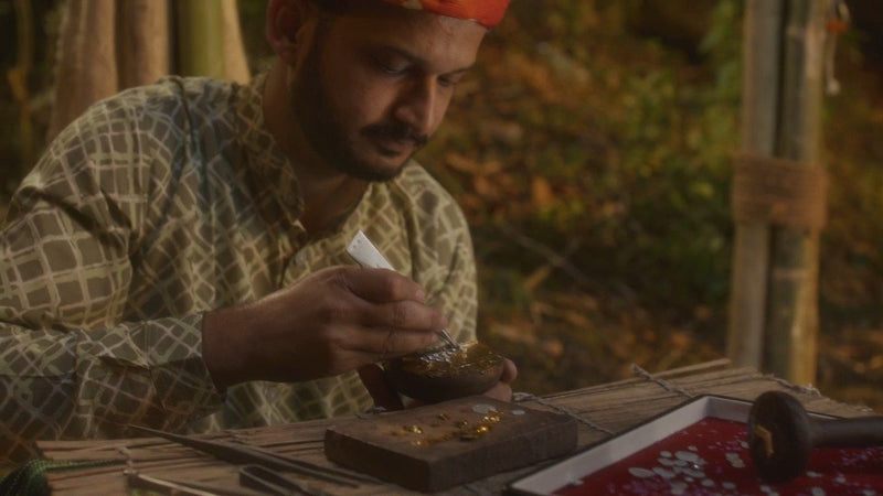 A karigar works on a piece at his bench