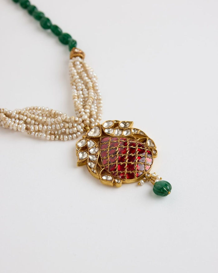A pendant of rubies in a gold lattice on strands of seed pearls