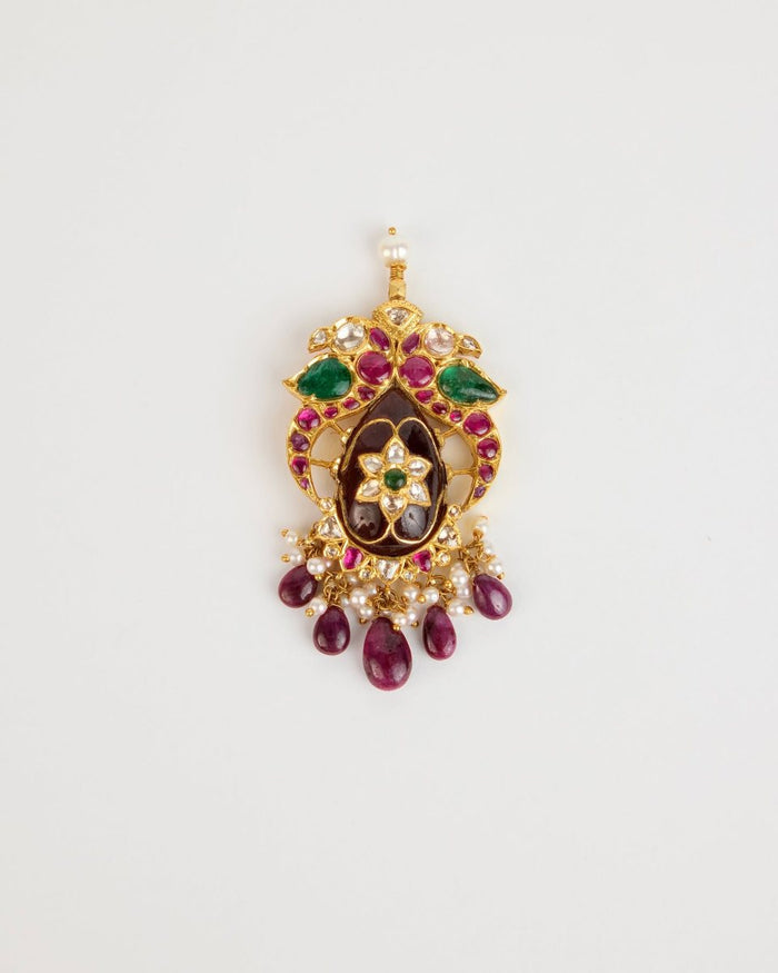 A kundan pendant of rubies, emeralds and polki with ruby drops