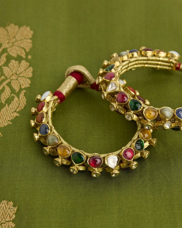 Navratna bangles of nine coloured stones on green silk
