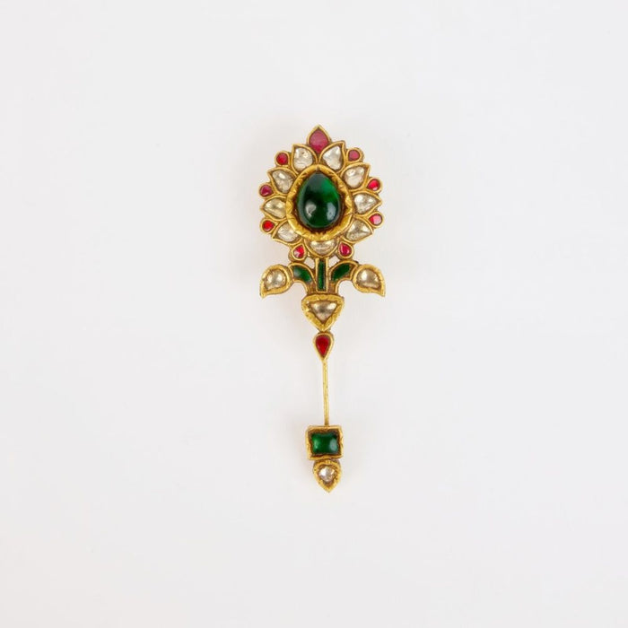 A pin of polki and an emerald in gold