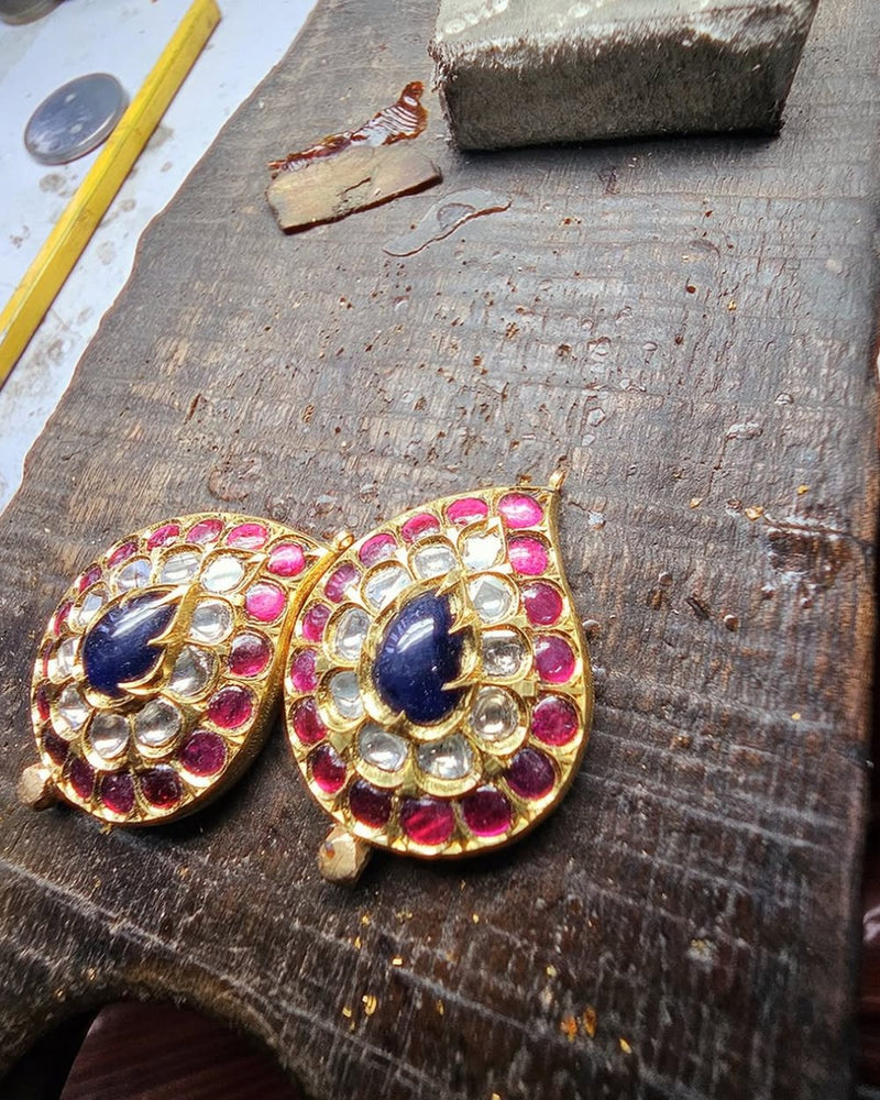 Earrings of polki, rubies and sapphires on a karigar’s bench